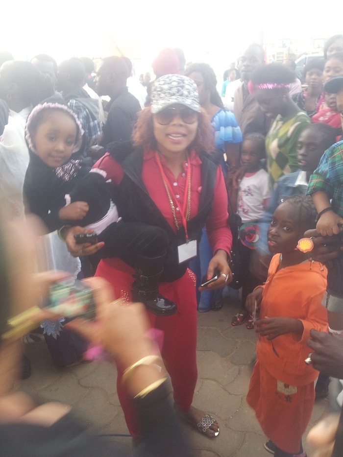 Amina Poté pose avec les enfants au stand du Groupe Futurs Médias