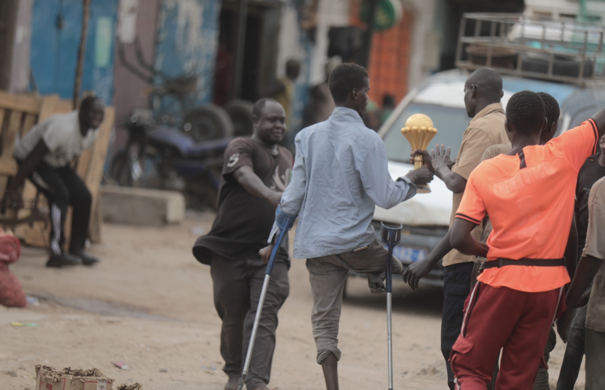 (EN IMAGES) Des personnes à mobilité réduite se pressent pour voir le trophée de la CAN