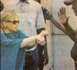 Mme Viviane Wade tend ses mains à un policier pour qu'il lui mette les menottes