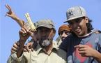 Des combattants du CNT brandissent un pistolet plaqué or qui appartenait à Kadhafi, à Syrte ( PHOTO  ) 