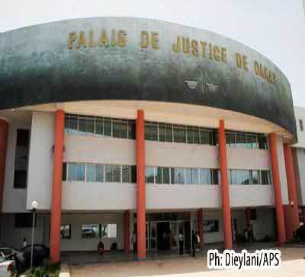 Attendant la délivrance d'un permis de visite, Abdoulaye Touré fume du yamba devant le bureau du doyen des juges.