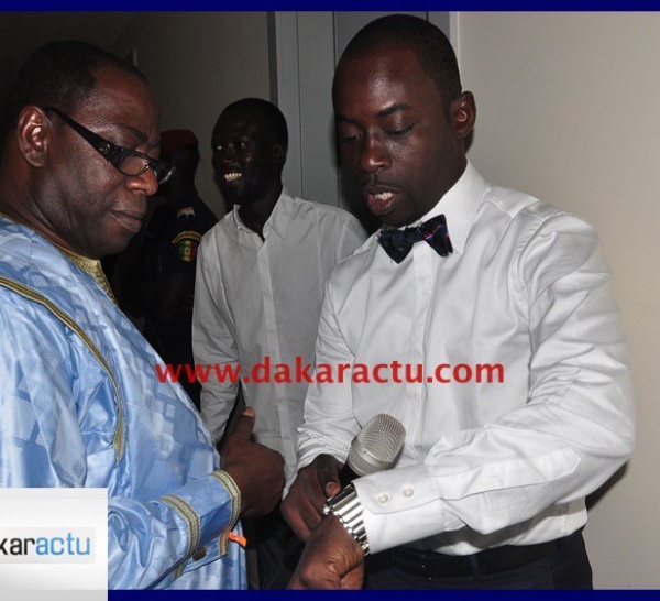 Boubacar Diallo avec son noeud papillon montrant sa montre à Mady Dramé